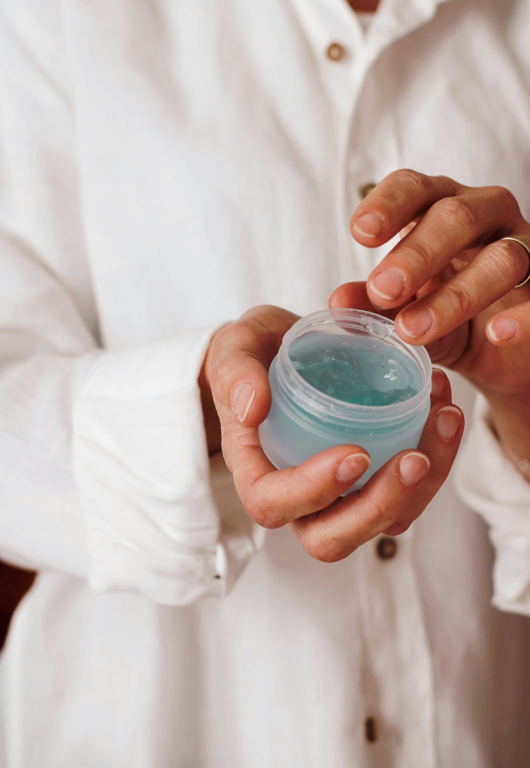 Personne en blouse manipulant un pot pour tester un produit de laboratoire.