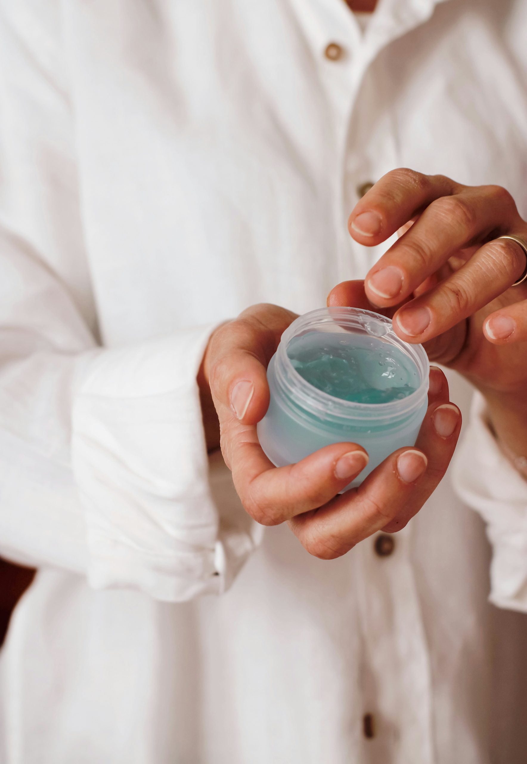 Personne en blouse manipulant un pot pour tester un produit de laboratoire.